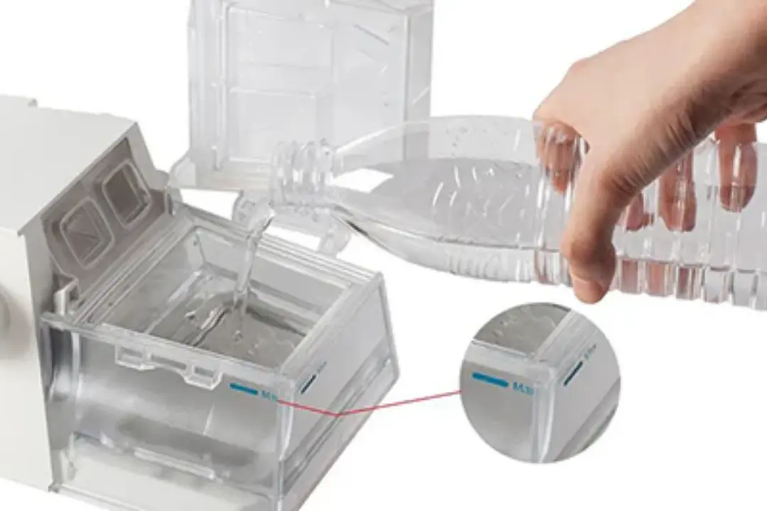 CPAP humidifier chamber being cleaned and refilled with distilled water