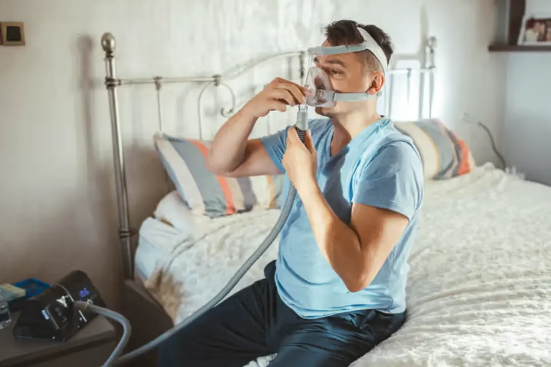 Person sleeping peacefully with CPAP machine after weight loss and therapy adherence
